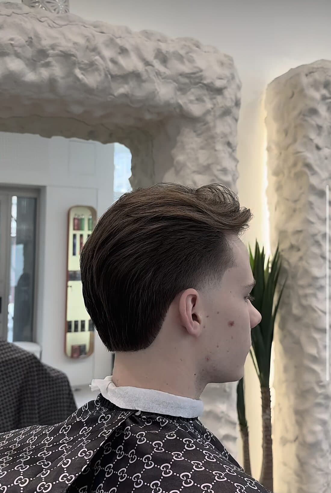 Klassischer Herrenschnitt mit Taper an den Seiten, im Spiegel des Salons