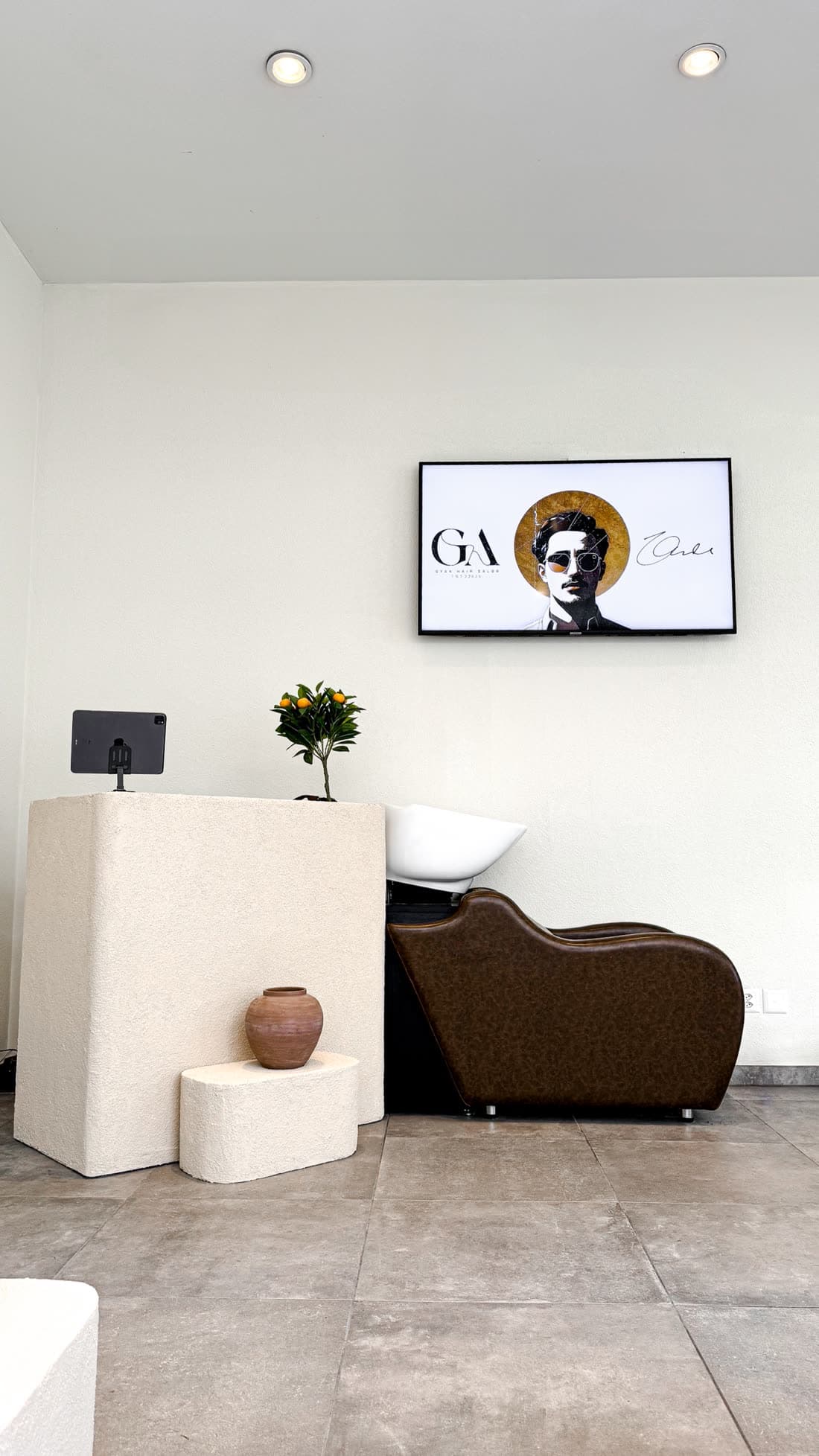 Empfang von GYAN Hair Salon mit Waschplatz und GYAN-Logo am Bildschirm