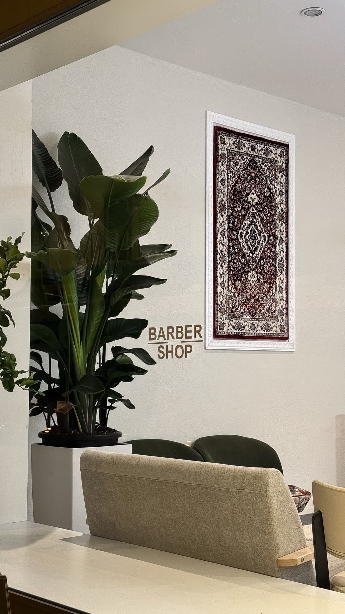 Barbershop-Ecke im GYAN Hair Salon mit Pflanzen und Teppichbild